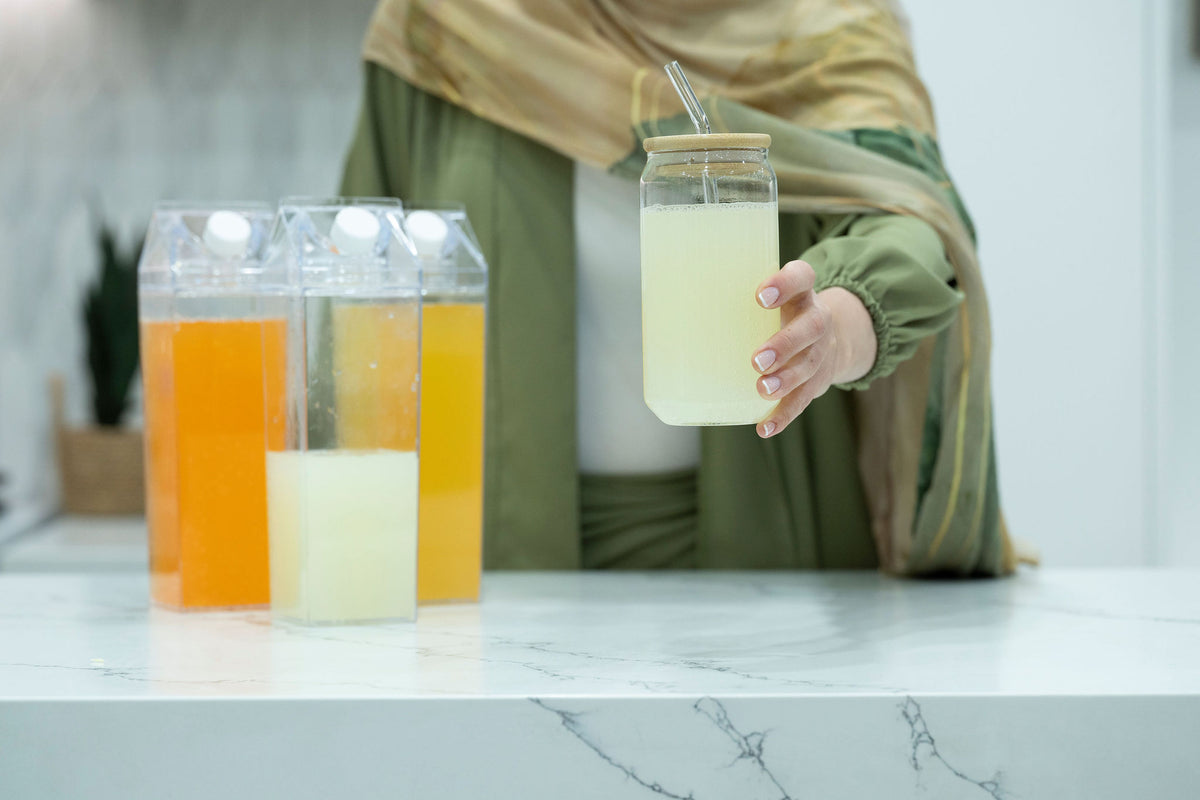 Clear Drink Container – 2 Liter showing assorted beverages in a modern kitchen setting, ideal for fridge storage and kitchen organisers.