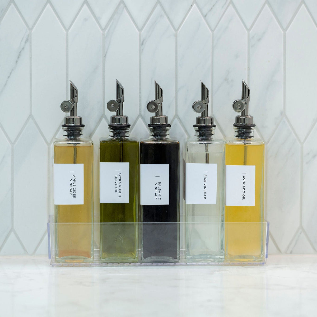 Glass Oil & Vinegar Bottles with Tray – 5 Pack displayed on kitchen counter for stylish pantry organisation.