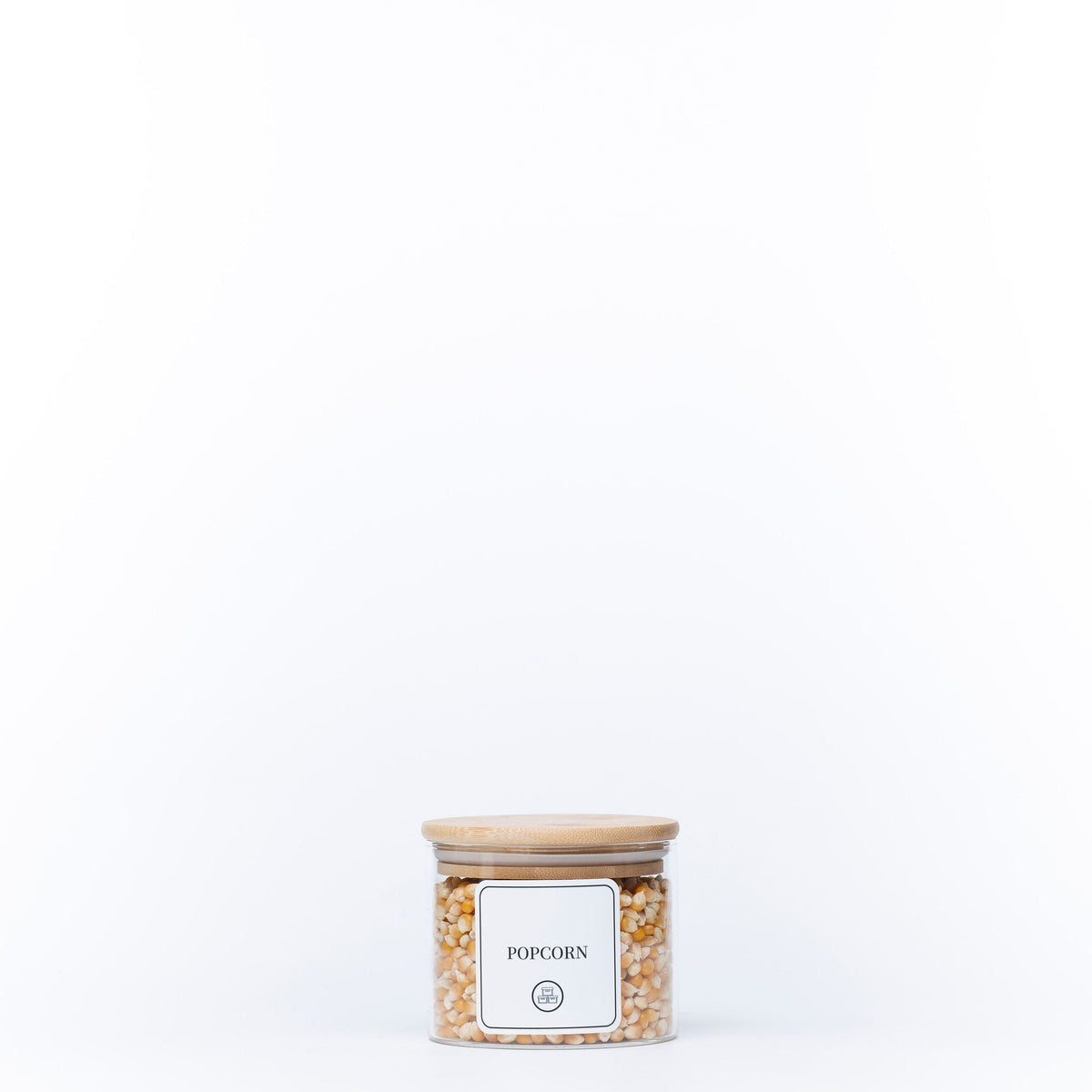 Round Glass Bamboo Storage Jar with lid filled with popcorn kernels, ideal for pantry organisation. Perfect for kitchen storage solutions.
