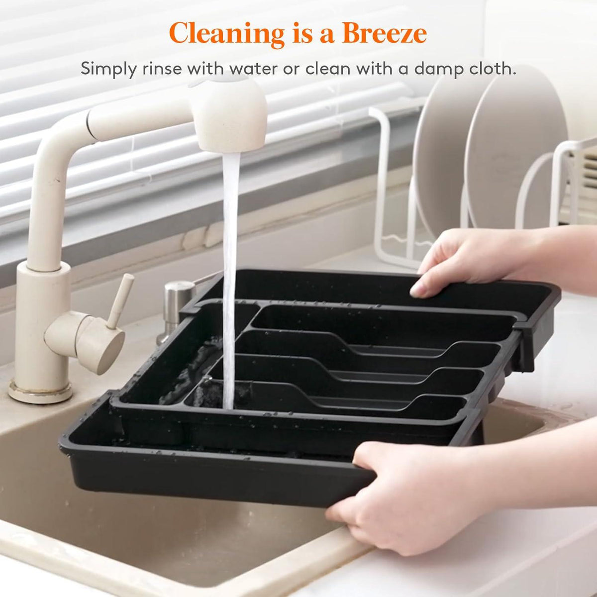 Hands rinsing Expandable Cutlery Drawer Organiser Tray – Black (7 Slot) at kitchen sink for efficient storage organisers.