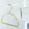 Gold hijab scarf hanger with semicircle design for organized storage.