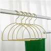 Gold hijab scarf hanger with elegant semicircle design on wardrobe rail.