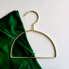 Gold hijab scarf hanger with green scarf, semicircle design for organized storage.