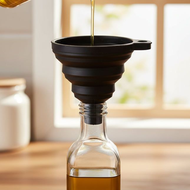 Black Foldable Silicone Funnel for Jars & Liquids used for kitchen organisation, pouring oil into a glass jar.